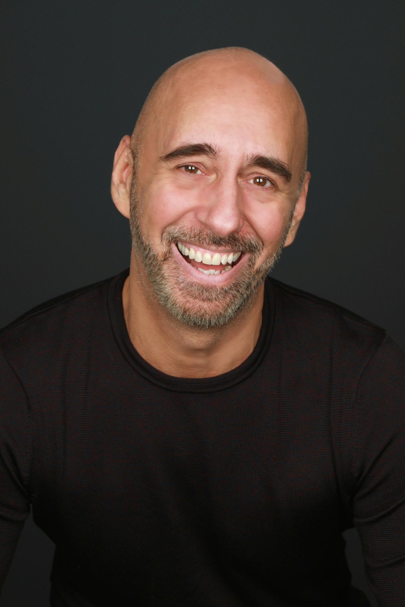 Andreas Pliatsikas smiling, studio headshot