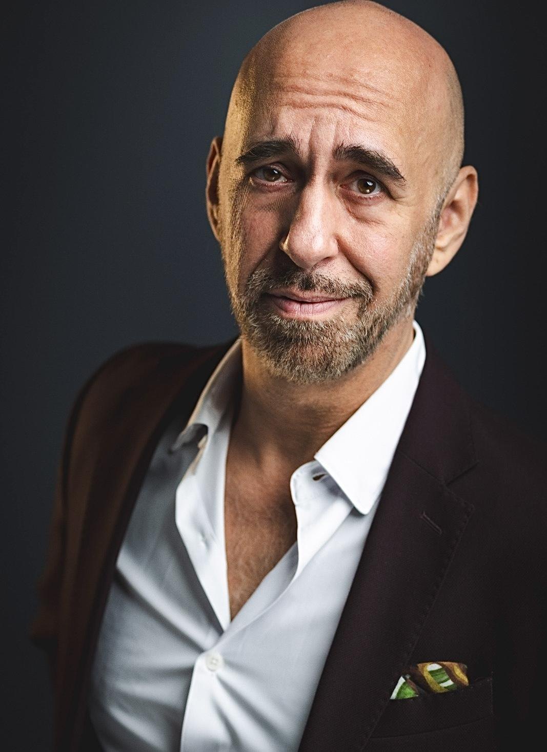 Andreas Pliatsikas in a dark suit, editorial headshot