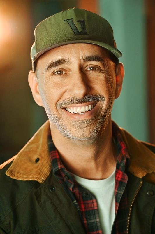 Andreas Pliatsikas in a cap and jacket, character portrait